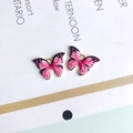 Makroaufnahme von zwei rosa-schwarzen Schmetterlingsanhängern mit goldenen Rändern für DIY - Rosa Und Schwarz (1#)