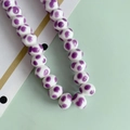 Dettaglio macro di perle in ceramica bianca a pois viola per la creazione di gioielli - Pois Viola (6#)