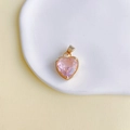 Gros plan d'un pendentif en pierre rose en forme de cœur avec cadre en cuivre doré - Rose (1#)