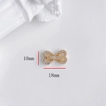Macro detail of a 18mm gold bow connector link with micro-set cubic zirconia - Double Heart Buckle