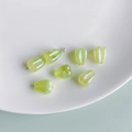 Macro detail of translucent tulip bud beads with iridescent finish for DIY jewelry making - Pale Green