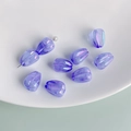 Macro detail of iridescent purple tulip glass beads and pearl needles for DIY jewelry - Purple