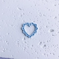 Close-up of light blue hollow heart charm with intricate lace edges for DIY jewelry making - Hollow Blue Heart