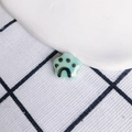 Detail view of a glossy mint green ceramic cat paw charm with brown painted paw prints - Mint Green(5#)