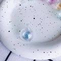 Makroaufnahme von irisierenden Glaskugeln mit Regenbogeneffekt in einer weißen Schale - 1# Blau