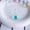 Close-up of a clear iridescent glass bubble pendant with blue pearlescent filling - Lake Blue