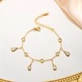 Nahaufnahme des vergoldeten Edelstahlarmbandes mit tropfenförmigen Zirkonia-Anhängern - Wassertropfen Runde Weiße Zirkonia Armband (7970) / Gold