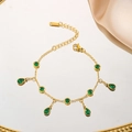 Elegantes Gold-Titanstahl-Armband mit grünen Zirkon-Anhängern auf einem Spiegeltablett - Wassertropfen Runde Grüne Zirkonia Armband (7971) / Gold