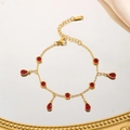 Detailansicht eines goldfarbenen Edelstahlarmbands mit roten Zirkonia-Anhängern - Wassertropfen Runde Rote Zirkonia Armband (7972) / Gold