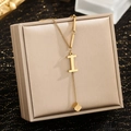 Detail of golden stainless steel letter I pendant with square tassel on jewelry box - Letter I