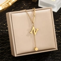 Close-up of gold stainless steel necklace with initial N pendant on jewelry box - Letter N
