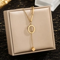 Detailed close-up of gold Y-shaped necklace with rectangle pendant on jewelry box - Letter O