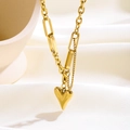 Detalle de collar de capas con colgante de corazón dorado sobre fondo textil - Corazón Puntiagudo (8861)