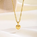 Primer plano de collar con colgante de corazón dorado y grabado Love sobre seda blanca - Corazón Pequeño Inglés (81269)