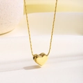 Primer plano detallado del colgante de corazón de oro pulido sobre seda blanca - Cadena de Bambú de Corazón (81361)