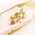 Detailaufnahme asymmetrischer Goldohrstecker mit rosa Kristall und Tierkreiszeichen-Zirkon - Waage Modell (Gold)