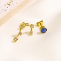 Detailansicht asymmetrischer Goldohrringe mit Zirkonia und einem blauen Geburtsstein - Zwillinge-Stil (Zwillinge Gold)