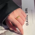 Bague en acier titane doré mat avec finition scintillante portée par un mannequin - US 5 / Doré mat