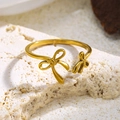 Detail eines 18K vergoldeten Schleifenrings mit gebürsteter Metallstruktur auf Stein - Doppelter Schmetterlingsknoten (3358) / Gold
