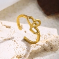 Makroaufnahme goldener Doppelherz-Ring auf Naturstein zeigt die 18K-Vergoldung - Doppelherz / Gold