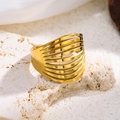 Nahaufnahme von vergoldetem Edelstahlring mit mehrlagigem Hohl-Design auf weißem Stein - Geometrische Streifen / Gold
