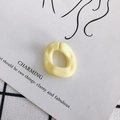Detalle de un dije cuadrado irregular de resina amarillo mate con textura de martilleo - Amarillo claro