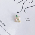 Makroaufnahme von Buchstabe K Anhänger mit rosa Blumen und goldfarbenem Rand - Buchstabe K