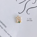 Detail eines goldenen Emaille-Buchstaben N mit rosa und gelben Blumen, 16x12mm - Buchstabe N