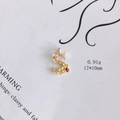 Detailansicht eines goldenen S-Anhängers mit rosa und gelben Emaille-Blumendetails - S