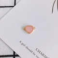 Close-up of pink resin heart pendant with gold rim and double rings for DIY jewelry - Pink