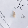 Détail macro d'un pendentif feuille plaqué or 18k avec zircone et dimensions 20x8mm - Taille 9