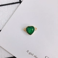 Macro detail of heart-shaped green resin pendant with gold trim and dual connectors - Green