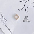 Vue macro d'un pendentif trèfle évidé plaqué or avec zircons et deux anneaux de fixation - 15#