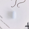 Primo piano di una perla cilindrica in resina azzurra su carta decorativa per gioielli fai da te - 10# Trasparente
