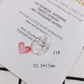 Macro detail of creamy white acrylic oval pendant size 22.5x17mm on wedding card - Minimalist Streamlined Ring (11#)