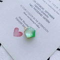 Vue macro d'un pendentif étoile en résine vert clair avec bordure dorée sur carte - Pendentif Étoile Vert Clair (6#)