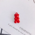 Macro shot of a red candy-colored bear pendant charm with metal ring for DIY jewelry making - Red