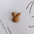 Vue macro d'une breloque lapin en résine mate pour bricolage et décoration de coques - Tête de Lapin Marron Clair (3#) / [attributs Du Produit] Il S'agit D'un Petit Accessoire En Forme De Tête De Lapin Marron Probablement Un Bijou À Réaliser Soi-même Un Aimant Pour Réfrigérateur Ou Une Pince Décorative Pour Coque De Téléphone Fabriqué En Résine. Le Produit Présente Une Finition Mate Et Une Forme Arrondie Et Mignonne. [présentation Visuelle] Une Simple Photo Macro Prise Du Dessus Est Utilisée Le Produit Étant Au Centre De L'image. Le Fond Est En Carton Blanc Avec Des Lettres Imprimées En Anglais Créant Une Image Lumineuse Avec Des Transitions D'ombre Et De Lumière Naturelles. La Qualité De L'image Est [élevée] Et Le Sujet Est Net. L'attrait Esthétique Est [élevé] Avec Une Note Globale De [82]. Les Accessoires Sont Bien Coordonnés Renforçant L'aspect Chaleureux Et Accueillant Du Produit. [contenu Textuel] Le Texte « Charm » Et Le Poème En Anglais En Arrière-plan Sont Des Éléments Décoratifs Qui Ne Nécessitent Ni Traduction Ni Suppression. L'image Ne Comporte Aucun Terme Marketing Chinois Ni Filigrane De Boutique. [étiquettes Logistiques] Aucune. Il S'agit D'un Produit Standard À Usage Général. [risque De Contrefaçon] Contrefaçon Du Produit : Aucune Car Il S'agit D'un Dessin Générique D'animal. Contrefaçon De L'arrière-plan : Aucune. [paramètres Du Produit] Les Dimensions Spécifiques Le Poids Et Les Autres Paramètres Ne Sont Pas Indiqués Sur L'image.
