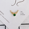Detailed view of gold angel wing pendant with small zircons and emerald green gemstone - Emerald Wings Style (14#)