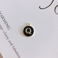 Detail of round black enamel pendant with gold letter Q and metal frame for DIY jewelry - Letter Q