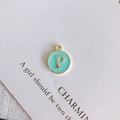 Detail of round gold-edged pendant with mint green enamel and letter P for DIY jewelry - Letter P