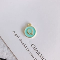 Detailed view of mint green enamel letter Q charm with gold-plated alloy finish - Letter Q
