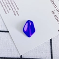 Close-up of irregular geometric electric blue resin charm with a smooth mirror finish - Size 8