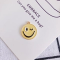 Macro di un ciondolo emoji giallo con occhiolino su un cartoncino regalo per gioielli - 16# Occhiolino