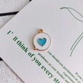 Detailed view of enamel heart pendant on decorative card for DIY jewelry making - Blue