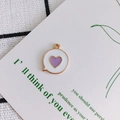 Detailed view of heart-shaped charm with white enamel finish and purple heart center - Purple