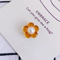 Detail van een barnsteenkleurige harsbloem met parelcentrum voor haaraccessoires - Oranje
