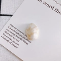 Macro shot of an oval marble textured pendant with amber veins on a white card - 2#