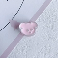 Close-up of pink resin bear DIY accessory with transparent edges and three holes - Pink