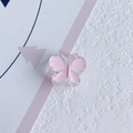 Vue rapprochée d'une breloque papillon en résine rose pour accessoires cheveux DIY - Rose